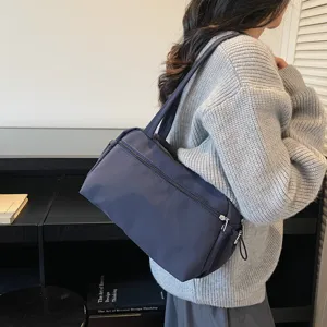 Vue détaillée d'un sac cabas d'épaule en nylon uni porté dans une scène quotidienne.