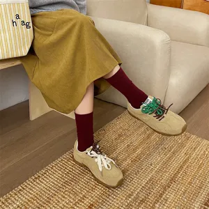 Gonna vintage in velluto a coste abbinata a calze bordeaux e sneakers retrò da donna.
