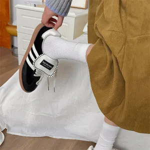 Sneakers casual retrò con tre strisce e linguetta risvoltata, design streetwear alla moda.