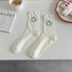White cotton mid-calf socks featuring cute cat embroidery and polka dot ruffles for women.