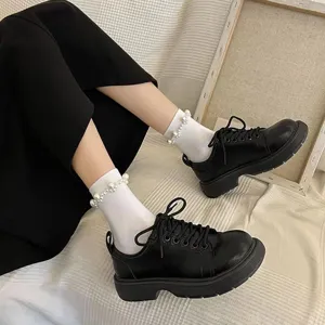 Détail des chaussettes mi-hautes Lolita JK japonaises ornées de perles avec chaussures noires.