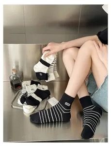 Black and white striped cotton socks detail showing cute embroidery and soft breathable fabric.