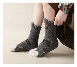 Close-up of thick coral fleece fuzzy socks with cute cat design and soft texture.