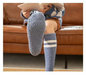 Cozy coral fleece fuzzy winter socks with white stripes, warm knee-high home socks detail view.