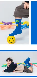 Detailed close-up view of children's blue mid-calf socks featuring smiley patches.