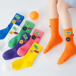 Colorful cotton children mid-tube socks with cute smiley face embroidery and letter patches.