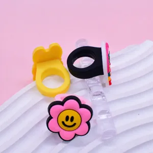 Vista di dettaglio anelli cartoni animati in PVC morbido, graziosi gioielli giocattolo per bambini.