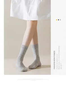 Gros plan de chaussettes mi-hautes grises pour femmes avec broderie nœud pour le printemps.
