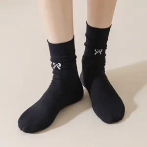Chaussettes mi-hautes noires pour femmes avec broderie de nœud blanc et coton respirant.