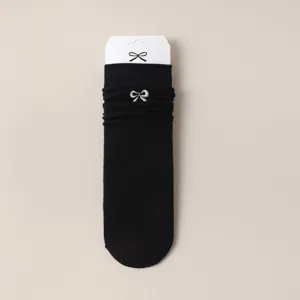 Chaussettes mi-hautes noires en coton pour femmes avec broderie de nœud mignonne.