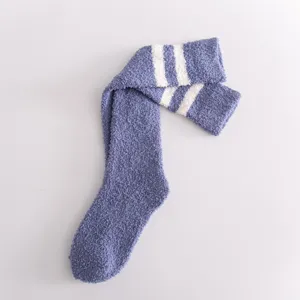 Cozy coral fleece fuzzy knee high socks with white stripes for women, warm winter home wear.