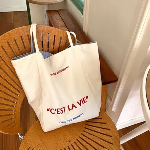 Details of the casual canvas tote bag displaying printed text and stylish background.
