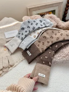 Close-up of cozy winter wool blend crew socks with leopard print and cute tags.