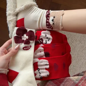 Close-up detail of plush cartoon bear and flower socks with cozy fabric and cute design.