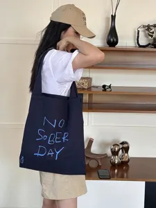 Canvas tote bag detail, casual large capacity shoulder bag with stylish letter print for daily use.