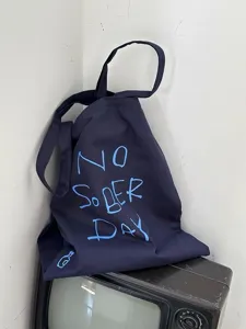 Detail view of casual dark blue canvas tote bag with blue slogan print for daily use.
