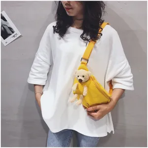 Cute yellow canvas chest bag for women, stylish crossbody shoulder bag with plush bear toy.