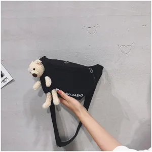 Black canvas fanny pack for women, featuring a cute plush bear doll, ideal for casual wear.