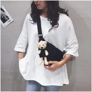 Close-up detail of the canvas chest bag featuring a cute plush bear pendant and strap.