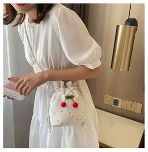 Vue détaillée d'un sac seau floral doux avec décor de cerises, sac bandoulière décontracté.