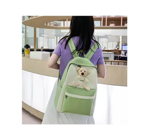 Detailed view of cute green white school backpack with plush teddy bear for daily student use.