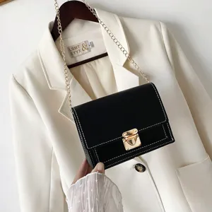 Chic black small square crossbody bag with gold chain and metal lock for women daily use.