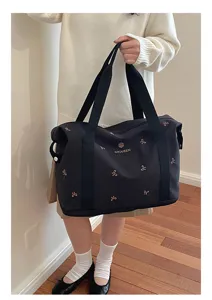 Women's black travel duffel bag with bow embroidery, large capacity gym and storage tote.