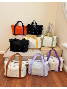 Large canvas travel duffel bag for women, stylish color-block weekender bag for gym.