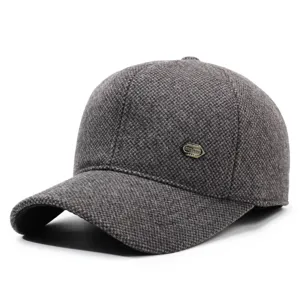 Close-up detail of the dark grey woolen baseball cap showing tweed texture and metal badge.