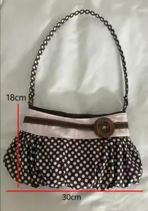 Vintage brown polka dot underarm bag detail, pleated cloud purse with a large wooden button.