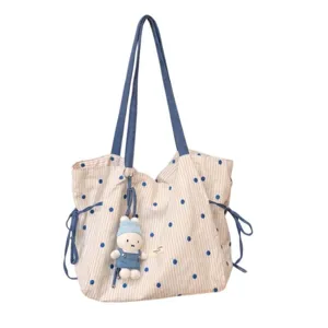 Blue polka dot canvas tote bag detail featuring cute bunny plush pendant and convenient side drawstrings.