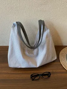 Detail view of casual striped canvas tote bag, lightweight shoulder underarm bag for women.