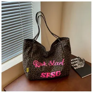 Vista dettagliata della borsa tote in tela con stampa leopardata vintage e lettere rosa per lavoro.