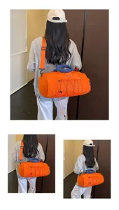 Detail view of the orange travel duffel fitness bag with mesh pocket and shoulder strap.