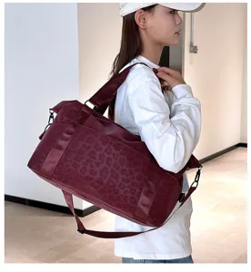 Large capacity dark red leopard print travel duffel bag with shoulder strap, detail view.