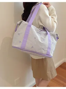 Large capacity travel duffel bag with shoulder strap and cute bow embroidery for women.