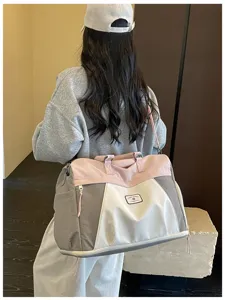 Detailansicht der großen Reisetasche mit praktischem Farbblock-Design in Rosa und Grau.