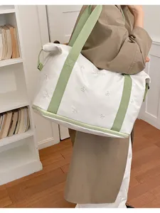 Large capacity canvas travel tote bag with green straps and cute embroidered bows for women.