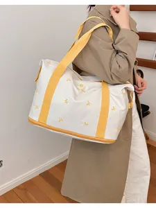 Large capacity canvas travel bag with yellow handles and cute bow embroidery details.