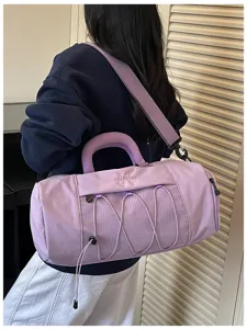 Detail shot of a lavender gym duffel bag featuring a mesh front pocket and elastic cords.