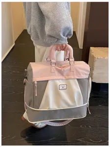 Detailansicht der großen Reisetasche im rosafarbenen und grauen Farblock-Design.