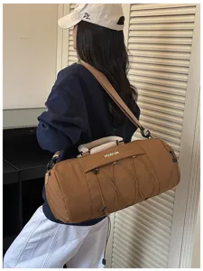 Detailed side view of large brown fitness duffel bag featuring front mesh pocket and strap.