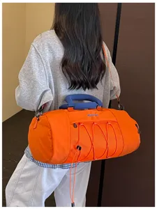 Orange cylindrical gym fitness duffel bag back wear detail view with drawstring mesh pocket.