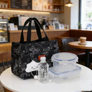 Black canvas lunch bag detail showing bear pattern, insulated lining, and cloud plush pendant.