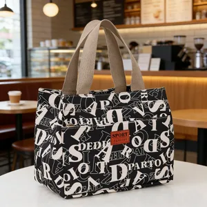 Detail view of the black canvas insulated lunch bag with letter print and front pocket for work.