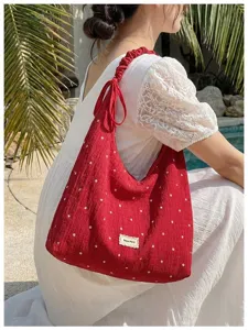 Vue détaillée du sac porté épaule plissé à fleurs rouges, cabas coréen décontracté en extérieur.
