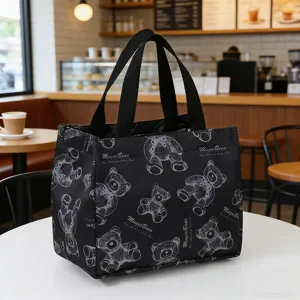 Detail shot of a black canvas lunch bag with cute bear pattern and insulation foil inside.