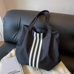 Minimalist black tote bag with white vertical stripes, large capacity casual shoulder bag.