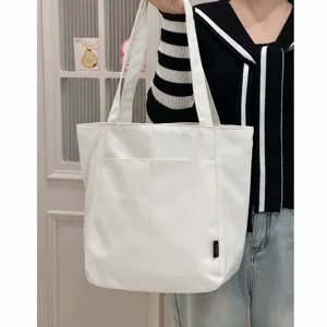 Detailed view of minimalist white canvas tote bag, large capacity daily shoulder bag style.