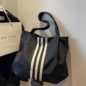 Black casual tote bag with white vertical stripes, large capacity stylish shoulder bag.